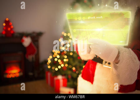 Immagine composita di santa tramite touchscreen futuristico a casa prima di natale Foto Stock