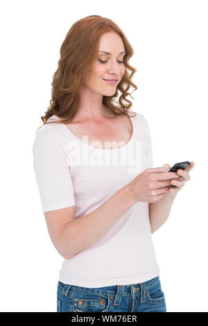 Pretty redhead inviando un messaggio di testo su sfondo bianco Foto Stock