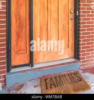 Cornice quadrata Home con mattoni e legno le sezioni di parete e vetrata di vetro porta anteriore e luce di posizione Foto Stock