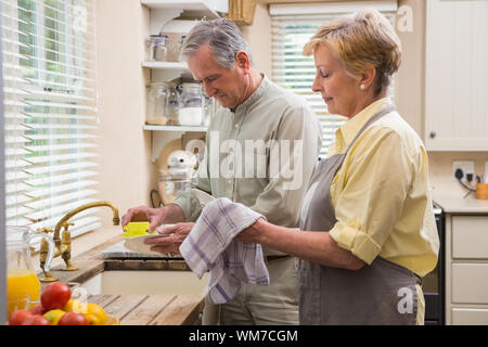 Coppia senior lavando i piatti a casa in cucina Foto Stock