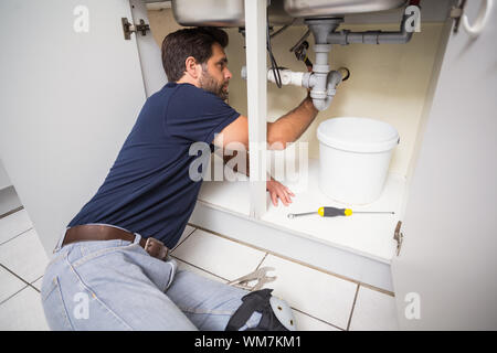 Plumber il fissaggio al di sotto del lavello in cucina Foto Stock