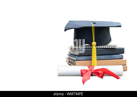 Close up graduazione nera PAC e certificato cartaceo con nastro rosso su una pila di libri vintage isolati su sfondo bianco. Istruzione celebrazione fo Foto Stock