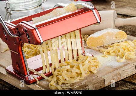 Produzione di pasta fatta in casa La pasta italiana La cucina del macinino, wood board, mattarello, tutti realizzati da farina di semola Foto Stock
