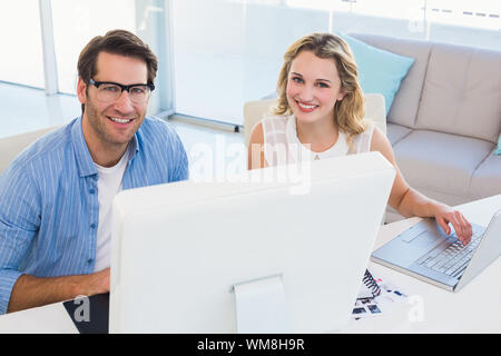 Foto di allegra gli editori che lavorano insieme su tavoletta grafica in ufficio Foto Stock