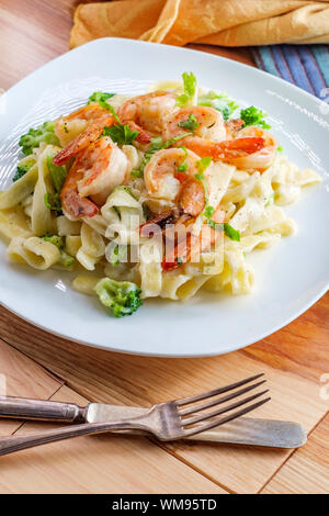 Italiano autentico fettuccine alfredo piatto di pasta con gamberi alla griglia e broccoli Foto Stock