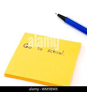 Andare a scuola parola su orange post it isolati su sfondo bianco Foto Stock