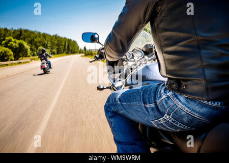 Bikers alla guida di un motociclo lungo la strada asfaltata (movimento sfocata). Visuale in prima persona. Focus sul cruscotto di un motociclo Foto Stock