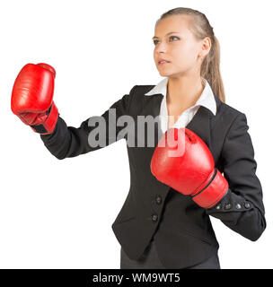 Imprenditrice indossando guanti da boxe in piedi in atteggiamento di inscatolamento, le sue labbra parted. Isolato su sfondo bianco Foto Stock