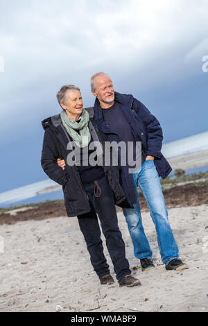 Felice anziani coppia senior camminando sulla spiaggia Foto Stock