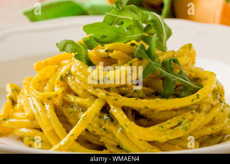 Foto di deliziosi piatti di pasta con zafferano e pesto di rucola Foto Stock