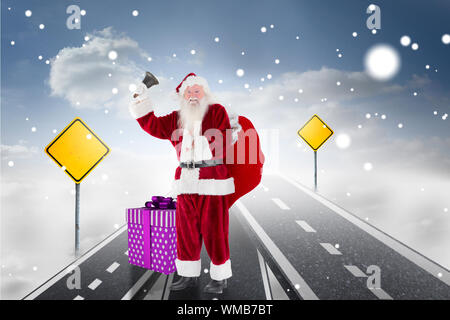 Babbo Natale campanello squilla contro la strada sopra le nuvole con cartelli stradali su di esso Foto Stock