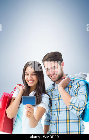 Coppia con borse di plastica e carta di credito contro il bollino blu Foto Stock