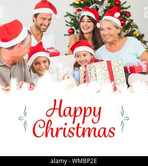 Immagine composita della famiglia felice a Natale lo scambio di doni contro il confine Foto Stock