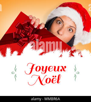 Immagine composita della donna sorpreso per la telecamera contro il Natale biglietto di auguri Foto Stock