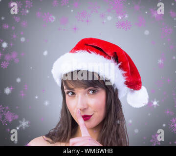 Festive brunette mantenendo un segreto contro il bollino grigio Foto Stock