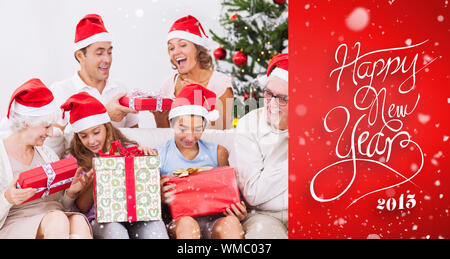 Famiglia eccitato scambiarsi i regali a Natale contro il bollino rosso Foto Stock