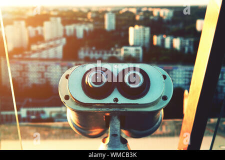 Binoscope - cannocchiale binoculare - finalizzata alla città in una splendida luce del tramonto. Estate, Minsk, Bielorussia. Piattaforma di Osservazione presso la Biblioteca Nazionale. Foto Stock