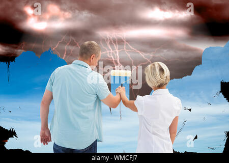 Immagine composita di felice coppia di anziani dipinto il cielo, da scuro a chiaro Foto Stock