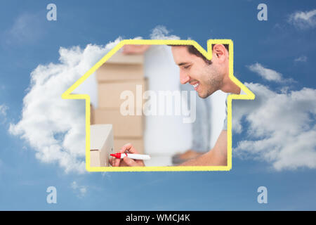 Uomo withmarker di scrittura sulla scatola di movimentazione contro il cielo nuvoloso Foto Stock