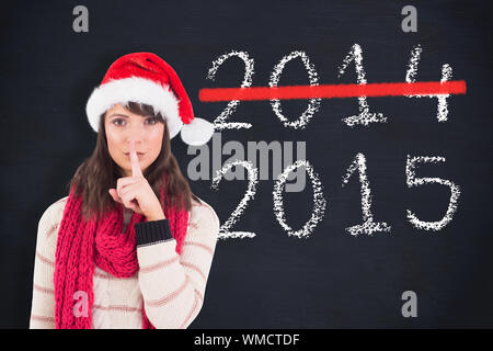 Festive brunette mantenendo un segreto contro di Blackboard Foto Stock