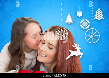 Madre e figlia con dono contro blu design fiocco di neve Foto Stock