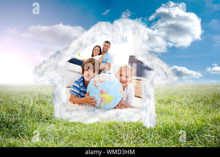 Bambini che giocano con un globo terrestre in casa contro il paesaggio soleggiato Foto Stock