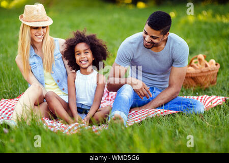 Immagine della coppia adorabile con la loro figlia avente picnic Foto Stock