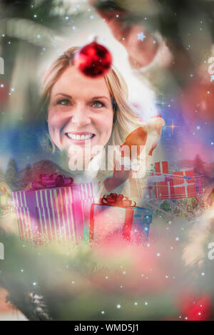 Immagine composita di santa spinge un carrello contro la caduta della neve Foto Stock