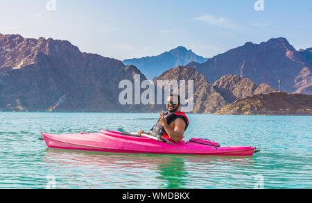 Giovane uomo kayak in Hatta Dam bellissimo luogo per acqua Attività avventura famosa attrazione turistica di Emirati Arabi Uniti Foto Stock