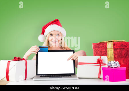 La donna rivolta verso lo schermo del notebook contro immagine composita della foresta di abeti Foto Stock