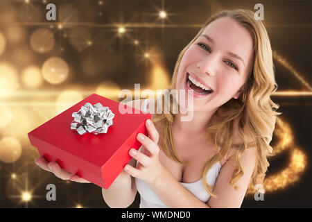 Ritratto di una donna felice ricevere un presente contro la luce di Natale design Foto Stock