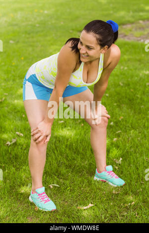 Montare sorridente brunette cattura il suo respiro nel parco Foto Stock