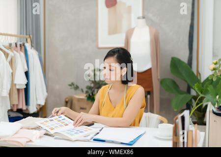 Un giovane stilista lavora sul suo atelier Foto Stock