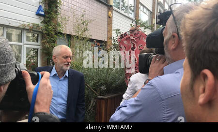 Un reporter tenta di dare leader laburista Jeremy Corbyn una camicetta al di fuori della sua casa nel quartiere di Islington, Londra del nord dopo essere stato bollato come grande ragazza camicetta da parte del Primo Ministro. Londra. Foto Stock