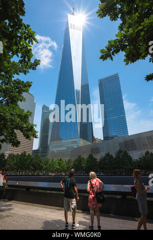 Freedom Tower New York, vista posteriore di una coppia matura in piedi accanto al 9/11 Memorial Sud Piscina e guardando le libertà torre, New York City, Stati Uniti d'America Foto Stock