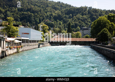 Il Flusswelle, un posto popolare per il surf e la Obere Schleuse coperto ponte sopra il fiume Aare in Thun, Svizzera. Foto Stock