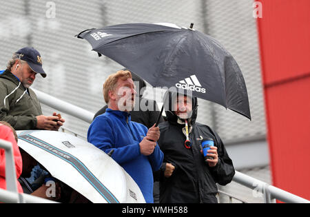 Ventole rifugiarsi sotto gli ombrelli da pioggia smette di giocare durante la giornata a due della quarta prova di ceneri a Emirates Old Trafford, Manchester. Foto Stock