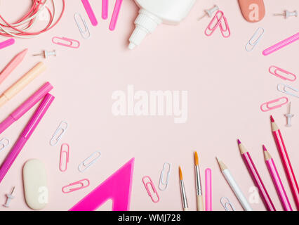 Forniture scolastiche di rosa e di colore bianco su sfondo rosa. Femmina o girlish ancora vita sul tema della scuola, studio, lavoro d'ufficio. Foto Stock