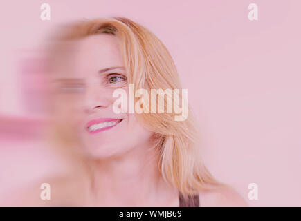 Donna sorridente con effetto non focalizzato su sfondo rosa-Spagna Foto Stock