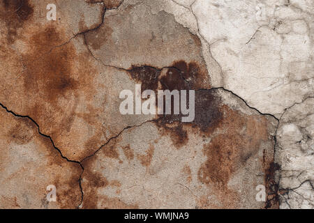 Incrinato intonaco della parete in cemento. Brown in scaglie di stucco rovinato facciata abbandonati. Addolorato sporco sullo sfondo. Abstract architettura grunge background. Foto Stock