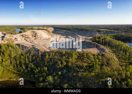 Paesaggio industriale con una grande cava di granito nel bosco vista aerea Foto Stock