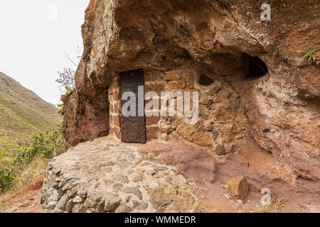 Grotta Antica dimora con metallo arrugginito porta, spazio di archiviazione a barranco seco, Anaga, Tenerife, Isole Canarie, Spagna Foto Stock