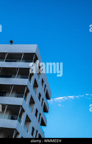 Abstract architettura, minimalismo geometrico, calcestruzzo appartamento o hotel blocco contro il cielo blu con nuvola piccola, Tenerife, Isole Canarie, Spagna Foto Stock