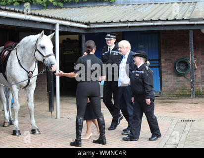 Il primo ministro Boris Johnson con il sergente Annette Twigg (destra) e West Yorkshire Police CHIEF CONSTABLE John Robins durante una visita a West Yorkshire dopo che il governo ha promesso di £ 750 milioni di ieri nel corso della revisione di spese per finanziare il primo anno di un piano per reclutare un extra 20.000 funzionari di polizia. Foto Stock