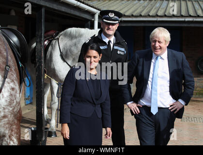 Il primo ministro Boris Johnson con Home Secretary Priti Patel and West Yorkshire Police CHIEF CONSTABLE John Robins durante una visita a West Yorkshire dopo che il governo ha promesso di £ 750 milioni di ieri nel corso della revisione di spese per finanziare il primo anno di un piano per reclutare un extra 20.000 funzionari di polizia. Foto Stock