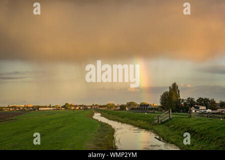 Un autunno doccia con rainbow in Olanda è illuminato dal sole Foto Stock