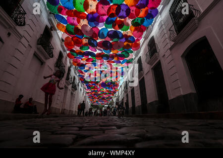 Caracas, Venezuela. 04 Sep, 2019. Una ragazzina salta per una foto sotto un ombrello coloratissimo cielo in una strada del centro della capitale venezuelana. L'installazione segue dal 'Ombrello Sky Prject' da Agueda, Portogallo. In Caracas attira i pedoni che sparare sotto i colori di ombrelli Selfies. Una volta ricco in Venezuela è in una profonda crisi economica. Almeno 2,3 milioni di persone hanno lasciato il paese. Credito: Pedro Rances Mattey/dpa/Alamy Live News Foto Stock