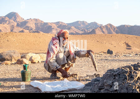 Bedouin la cottura del pane nel fuoco aperto e tradizionale metodo usando acqua di sale e la farina nella biosfera Dana. Foto Stock