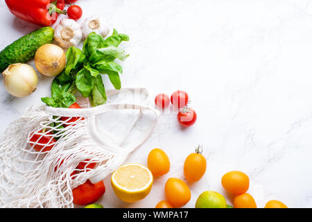 Immagine di overhead di sani ingredienti cottura sulla superficie di marmo con copia spazio. La cucina vegetariana concetto. Pomodori, insalata, basilico e peperoncino. Foto Stock