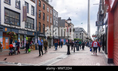 North Earl Street,Dublin, Irlanda, una frequentata zona per lo shopping che conduce a O'Connell Street con la guglia in distanza. Foto Stock